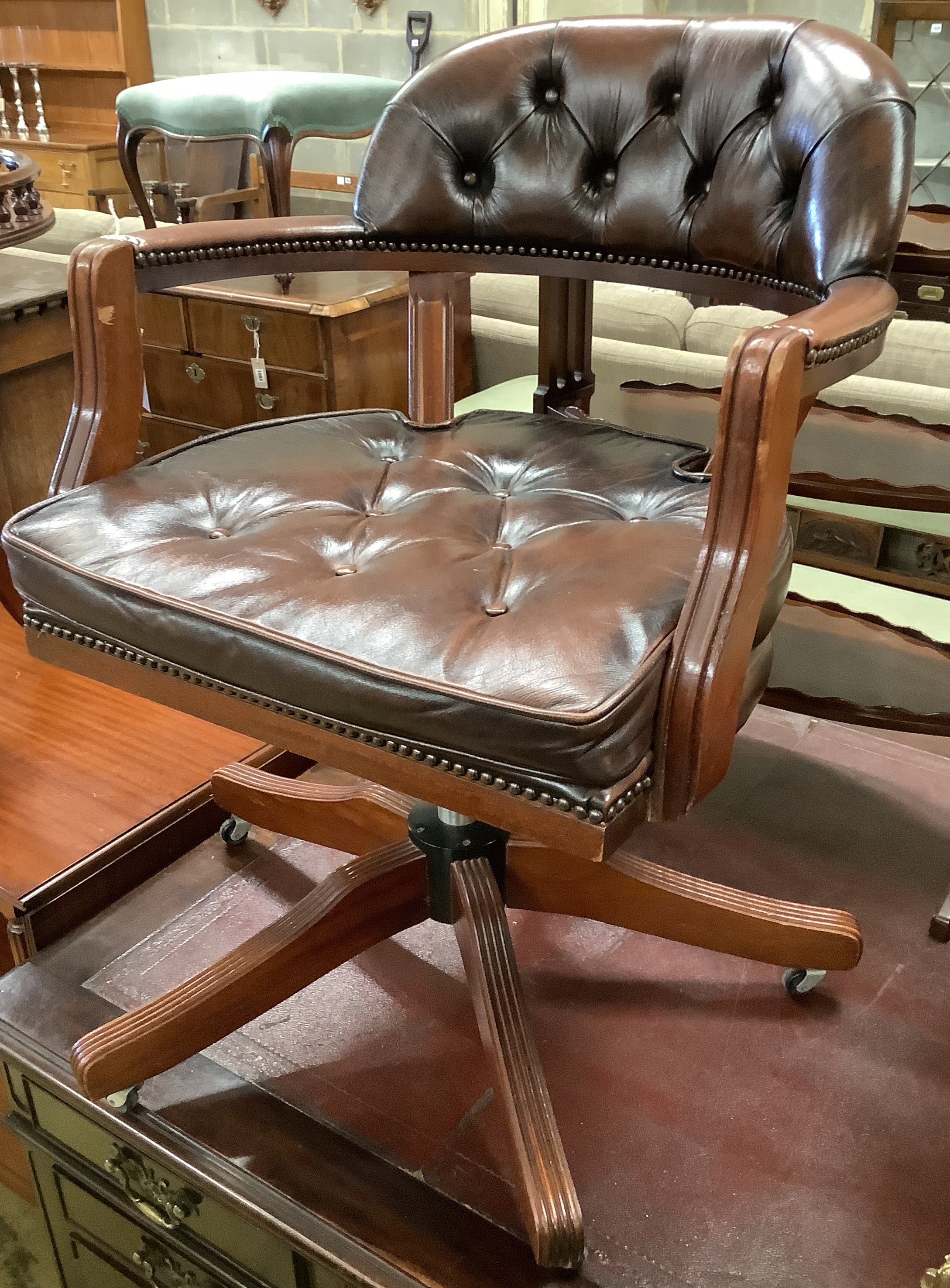 A mahogany and buttoned brown leather swivel desk armchair, width 60cm, height 84cm